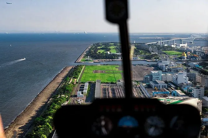 Private helicopter banking over Tokyo Bay and Rainbow Bridge at dusk on a Tokyo helicopter tour